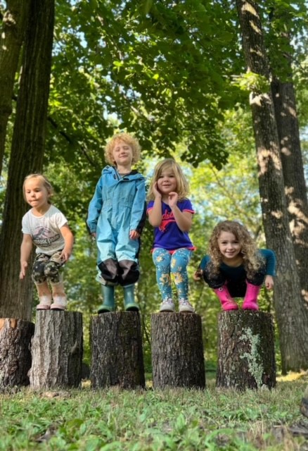 NB Group of children standing on logs